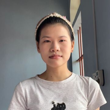 Young woman wearing a headband and white t-shirt.