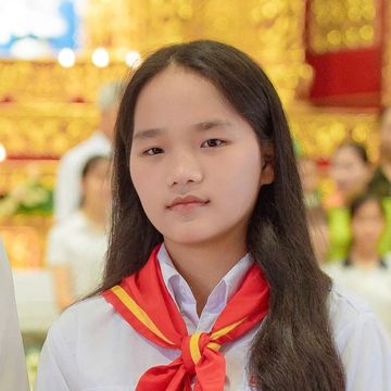Young girl in a white shirt with a red scarf.