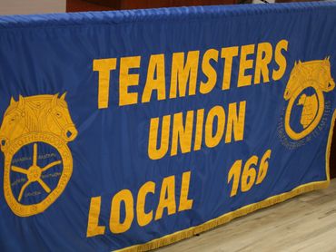 Blue banner with yellow text for Teamsters Union Local 166.