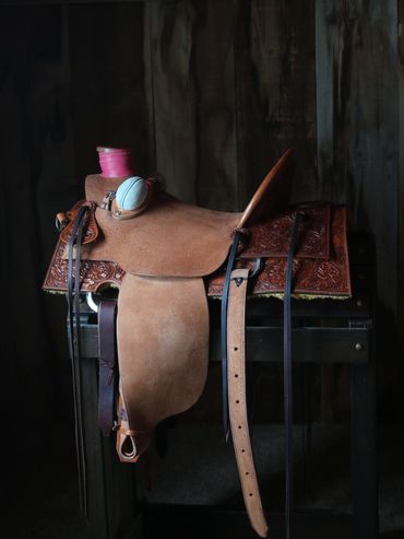Western leather horse saddle on a stand.