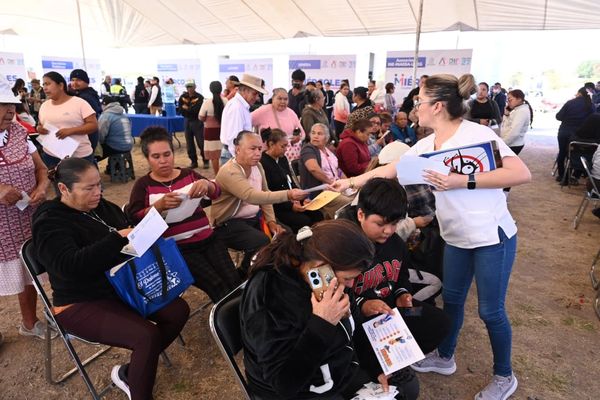 People gathered under a tent receiving information and assistance.