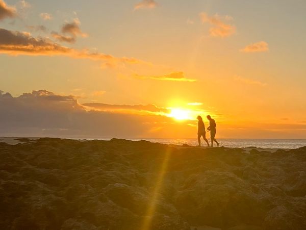 Couple walking on the beach at sunset 