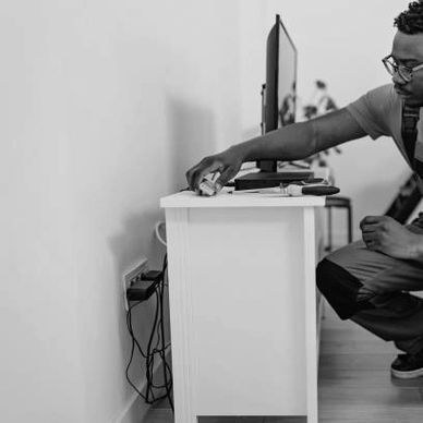 Handyman measuring and setting up home electronics during an in-home service in Houston.