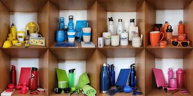 Color-coordinated drinkware and accessories neatly arranged on wooden shelves.