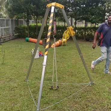 Metal swing set with safety stripes in a grassy yard.