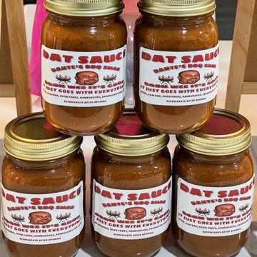 Five jars of Dat Sauce from Dante's BBQ Shack arranged in a pyramid.