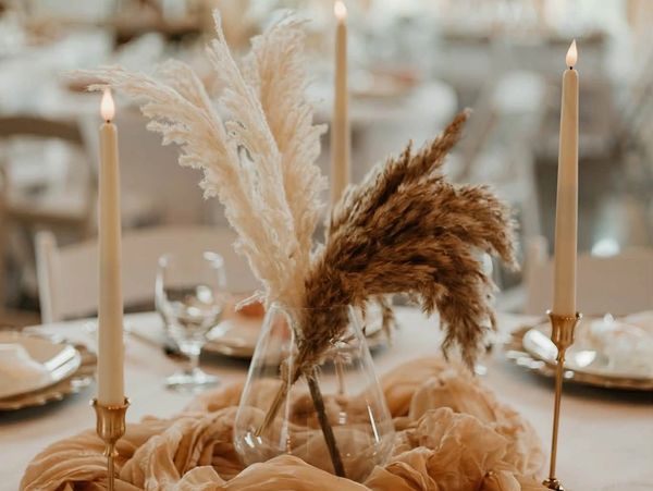Elegant dried floral arrangement centerpiece with lit candles.
