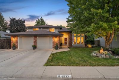 A cozy two-story house with a well-maintained lawn at dusk.
