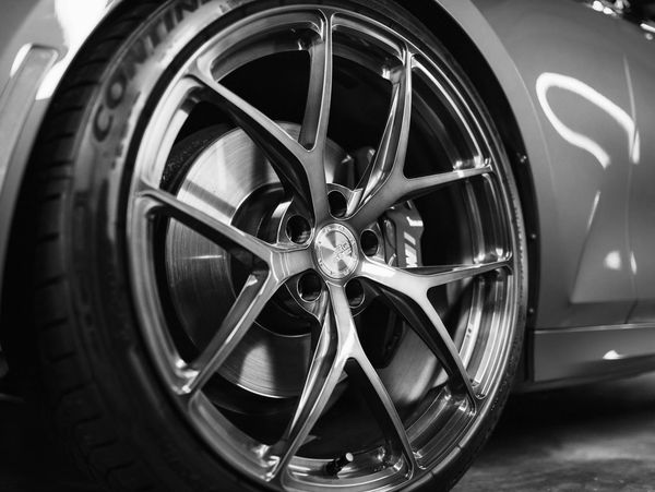 Close-up of a bronze alloy wheel on a blue car with visible brake caliper.