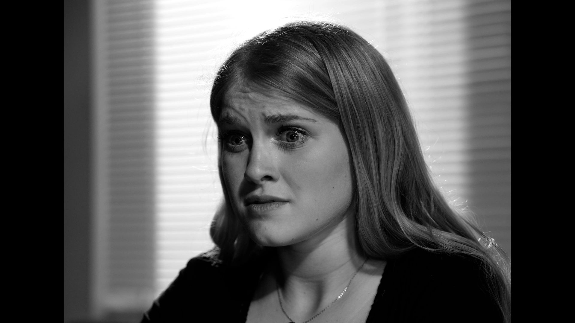 Black-and-white close-up of a woman with a worried expression.