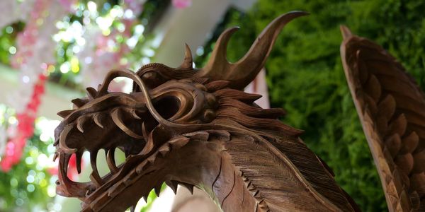 Intricately carved wooden dragon sculpture with detailed features.