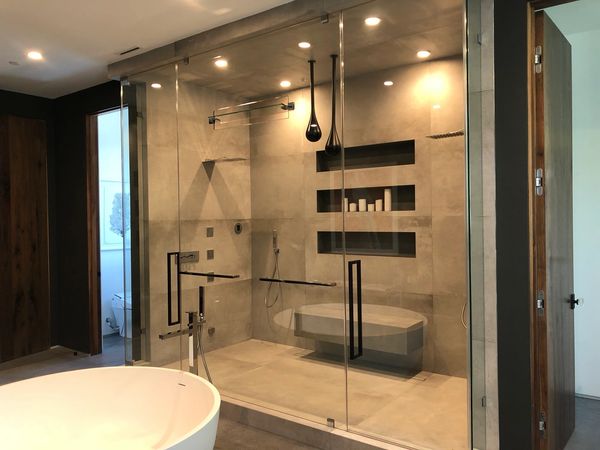 Top to bottom frameless primary shower enclosure with custom vent cut-out