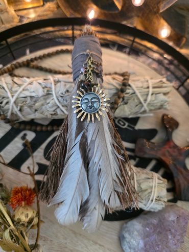 Decorative feather charm with sun pendant.
