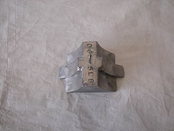 A metal weight with numbers stamped on it.