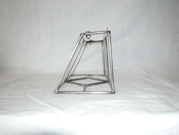 A geometric metal wire frame sculpture on a white surface.