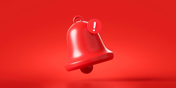 Rendering of a red alert bell with an exclamation point on a red background