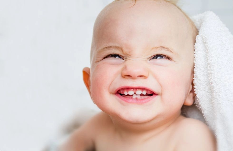 Bebe riendose enseñando los dientes de leche