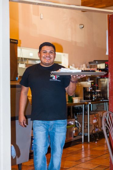 A man holding pizza plate smiling