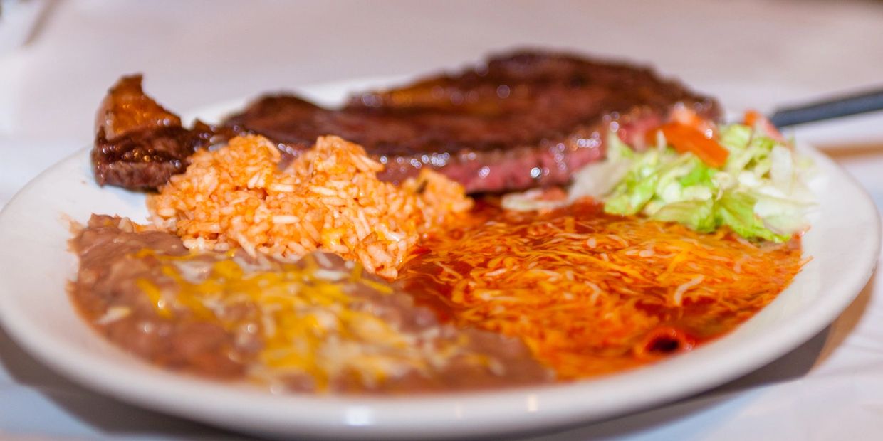 A picture of flavored rice, salad and steak