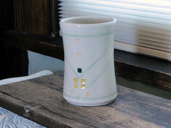 Mug cup in white with line angle design. small squares and color. 8 ounces.