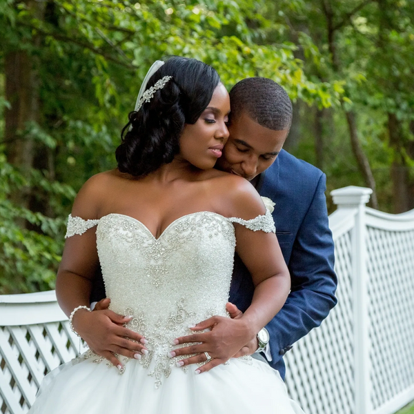 wedding photo of a bride being embraced from behind by her groom