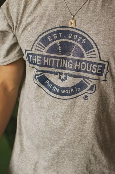 Gray t-shirt with a baseball-themed logo and the text 'The Hitting House'.