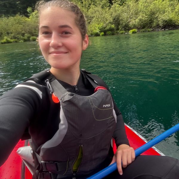 Young woman kayaking on a calm river.