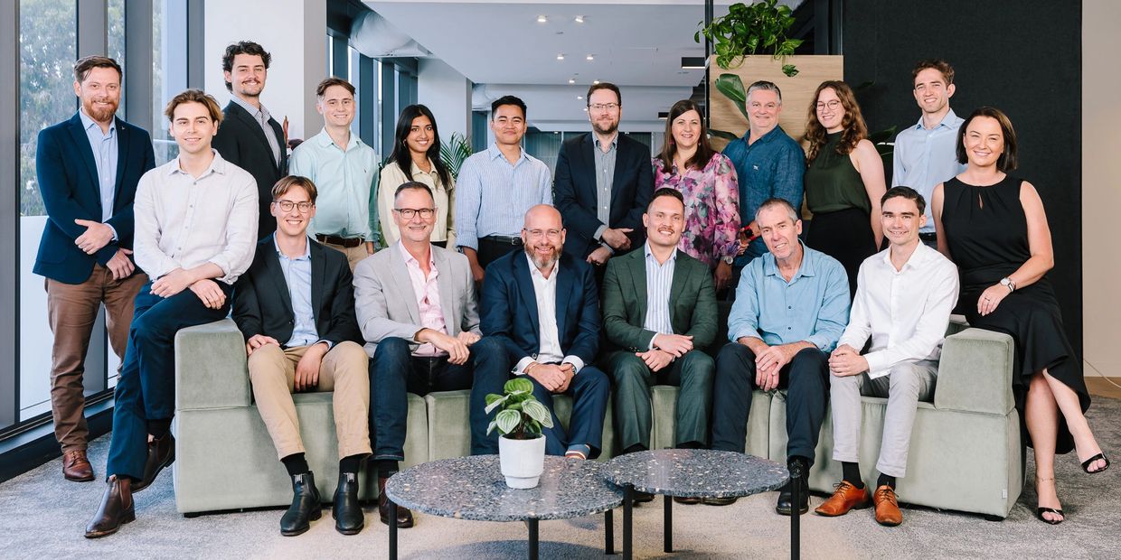 A diverse group of professionals posing in a modern office lounge area.