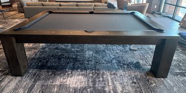 Modern dark pool table in a living room.