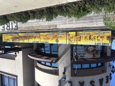 Exterior of a building with Surf City banners and curved windows.