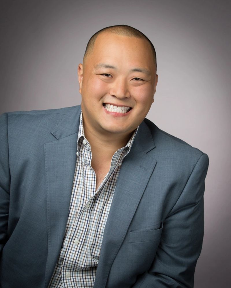 Stack of books next to pencils in a holder and a camera.