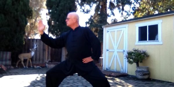 A serene landscape featuring mountains, a lake, and a clear blue sky with scattered clouds.