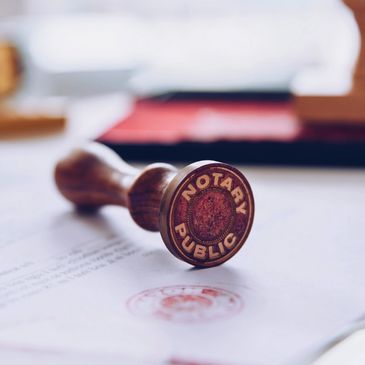 A wooden notary public stamp on a document with a red seal.