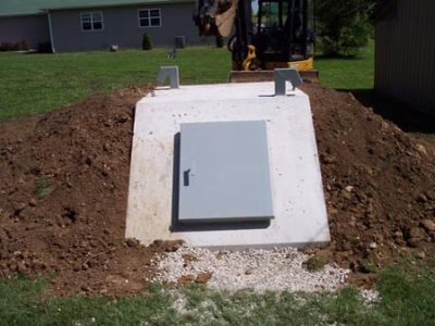 Concrete bunker door in a dirt mound.