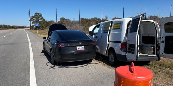A mobile service van provides roadside EV Charging to a blue Tesla.
