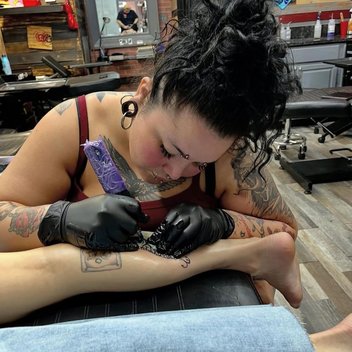 Girl tattoo artist tattooing at empire ink studios Miami Beach best tattoo artists in miami