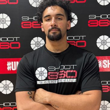 Man with folded arms wearing a Shoot 360 Basketball t-shirt.