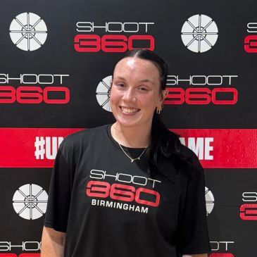 Smiling woman in a Shoot 360 Birmingham shirt stands against a branded backdrop.