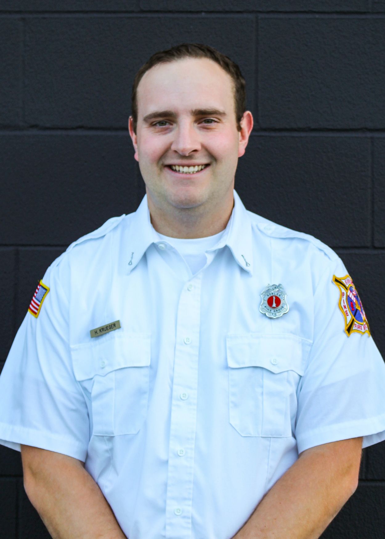 Smiling firefighter in uniform with name tag H. Krueger.