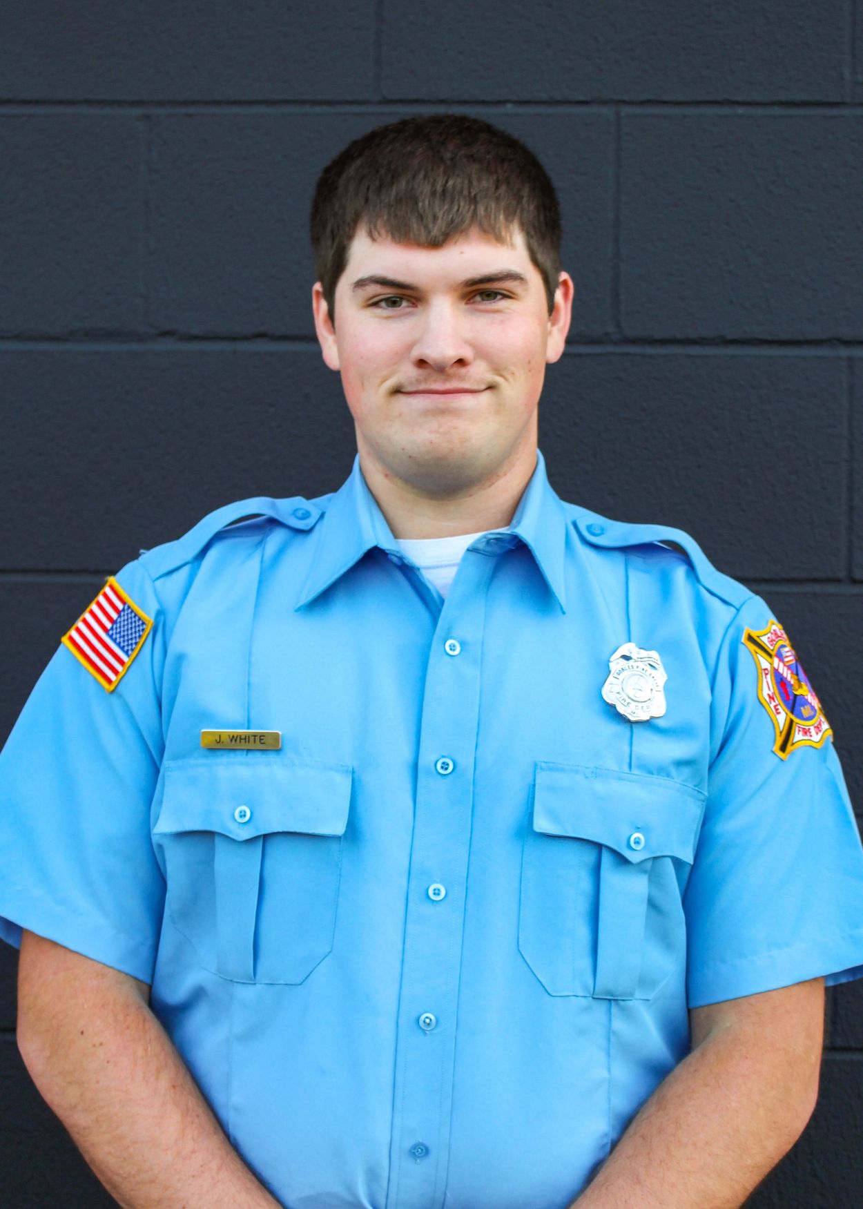 Young firefighter in uniform smiling.