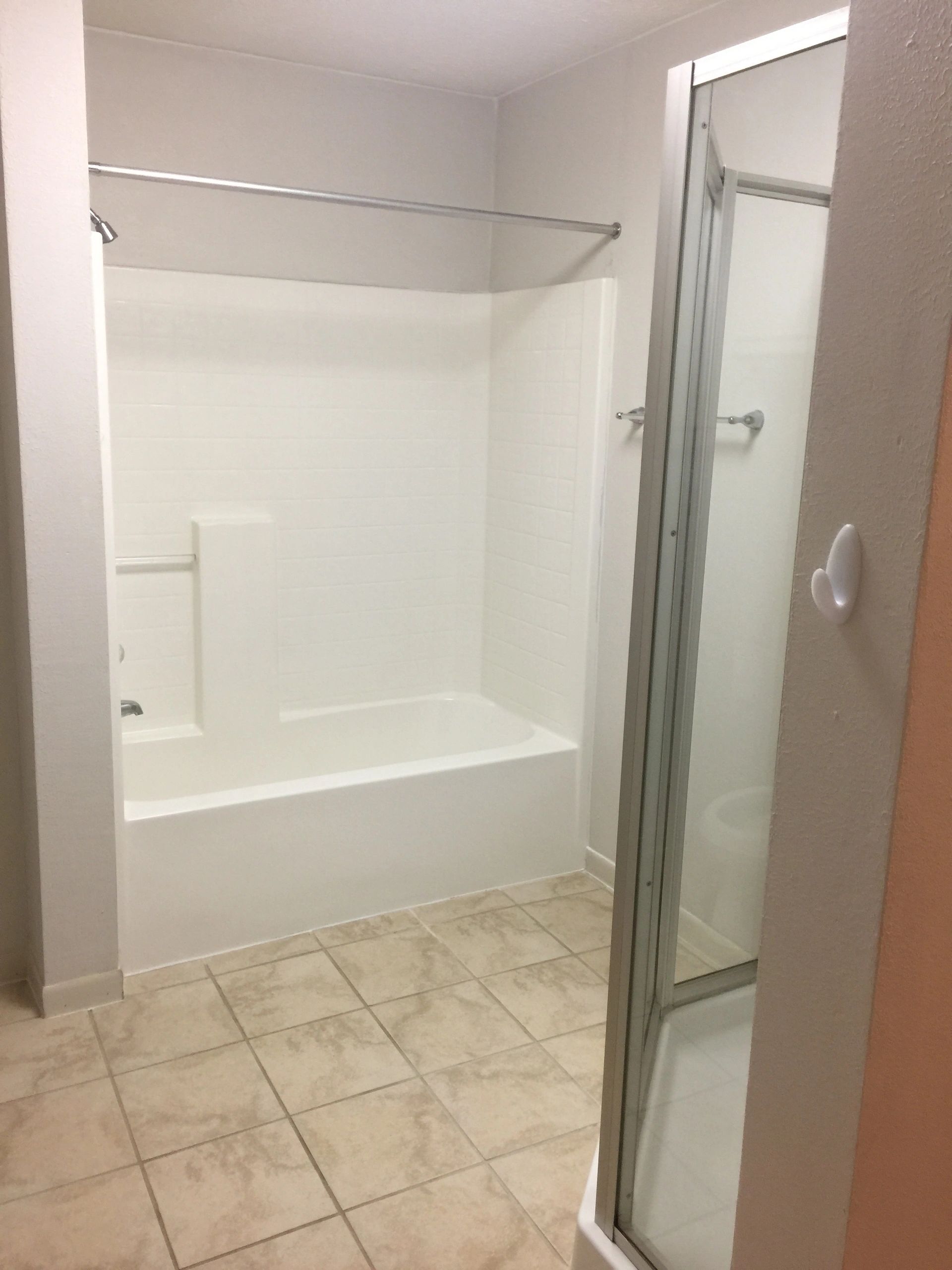 Clean bathroom with a bathtub and separate shower stall.