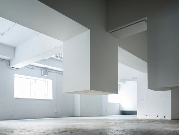 Empty industrial space with hanging geometric shapes.