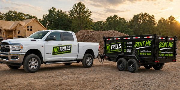 White Ram truck towing a black trailer with No Frills rental signage.