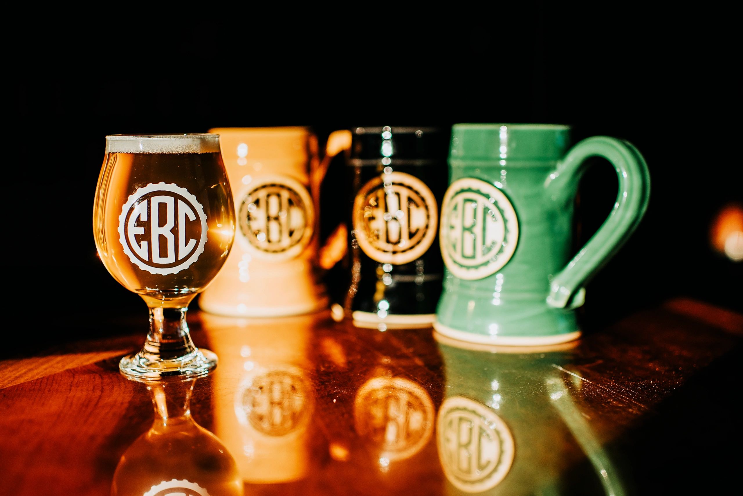 A picture of several EBC mugs and a tulip glass with a light-bodied beer.