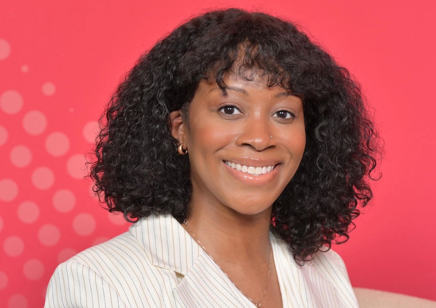 Headshot of Temnee Wright, an in-house commercial attorney, against a pink background.