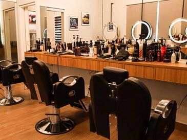 Interior of a modern barbershop with chairs and grooming products.