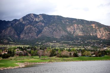 A serene lake with mountains in the background under a cloudy sky.