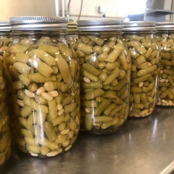 Jars filled with pickled green beans and white beans.