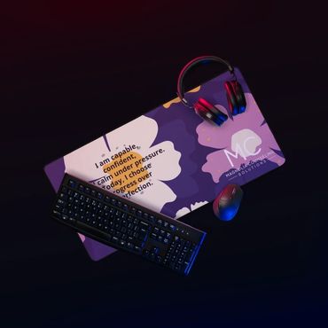 purple desk mat with magnolia flowers with a mouse keyboard and headphones placed atop