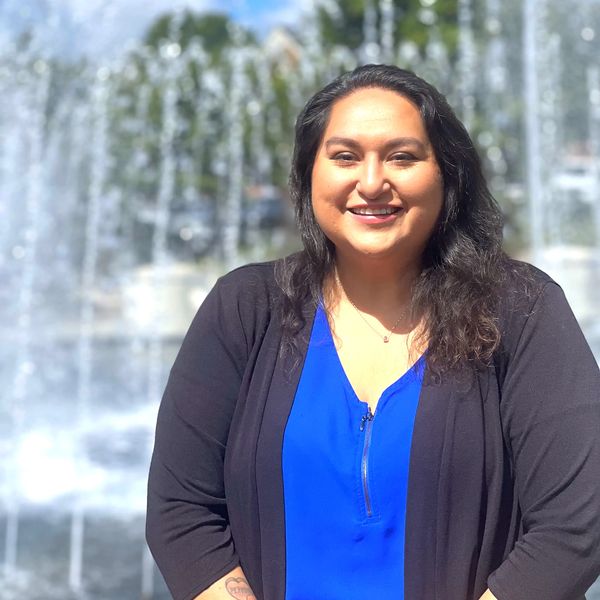 Veronica Rector sitting in front of fountain in a blue blouse